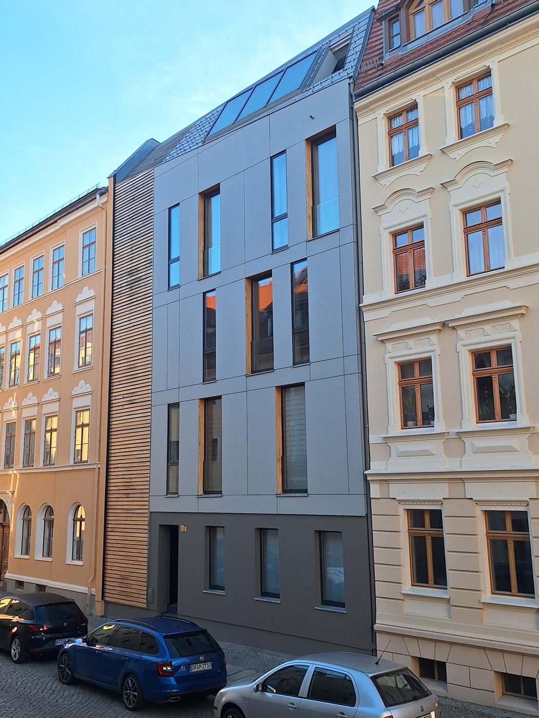 Saniertes Wohnhaus mit neuer, gedämmter Fassade zwischen historischer Bebauung